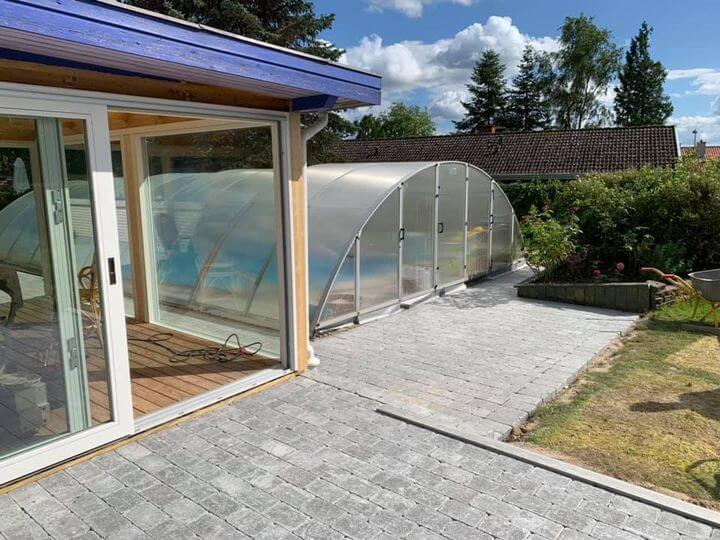 brolægning, terrasse belagt med brosten, i baggrunden ses en overdækket pool